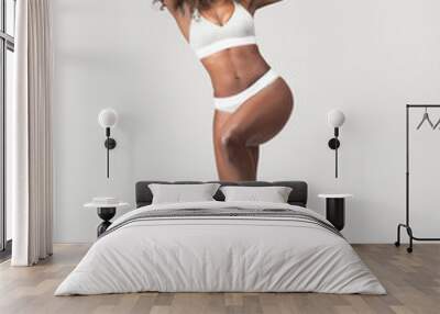 Happy beautiful African American Girl with wild curly hair and wearing underwear in studio with a gray background  Wall mural