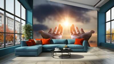 Human hands on sky background with sun rays. Concept of help, support and hope. Wall mural