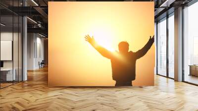 Human hands open palm up worship on sunset sky background. Wall mural