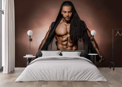 Muscular African American Black athletic fitness model wearing  black hoodie with six pack abs in studio with dramatic lighting against a brown background   Wall mural