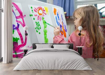 Little girl painting on paper Wall mural