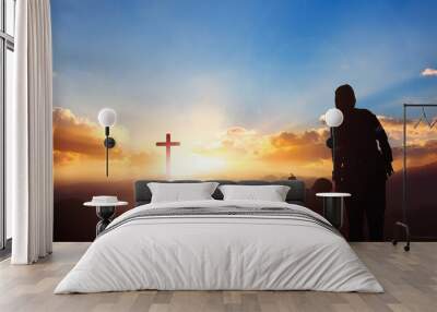 Silhouette mom and son looking for the cross on meadow autumn sunrise background Wall mural