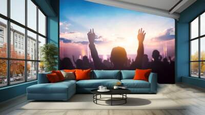 Worship and praise concept: christian people hand rising on sunset background Wall mural