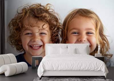 Two children with curly hair smiling and looking at camera Wall mural