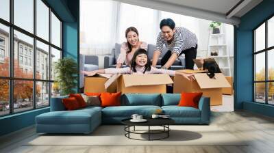 Asian family father mother daughter girl packing cardboard box relocation moving to new house, online marketing e-commerce unpacking stuff belongings home delivery. Lifestyle asian family together Wall mural