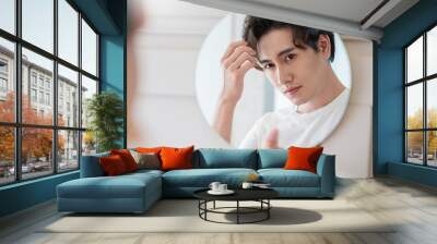 Closeup portrait of handsome beautiful asian boy mirror makeup routine with copy space. Beauty influencer guy with perfect glow skin dress up. Healthcare man lifestyle cosmetic blogger hair concept Wall mural