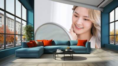 Closeup portrait young beautiful asian girl with mirror makeup routine with copy space. Beauty influencer woman perfect glow touch skin dress up. Healthcare woman lifestyle cosmetic blogger concept Wall mural