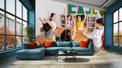 Multicultural group of students raising hand in class on lecture education, elementary school, learning people concept. Group team work of school kids with teacher sit in classroom floor raising hands Wall mural