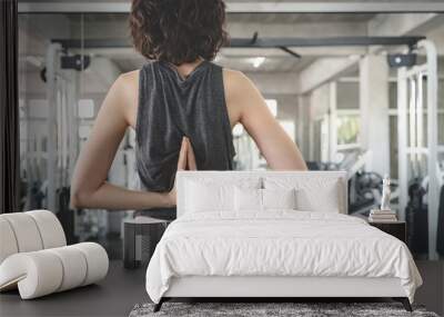 young fitness woman execute exercise with exercise-machine in gym. Wall mural