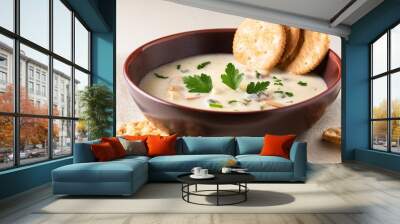 a bowl of creamy clam chowder topped with fresh parsley served with a side of crackers Wall mural