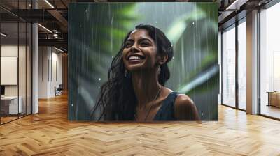 Happy beautiful Indian girl under tropical rain. Wet hair and shirt. Wall mural