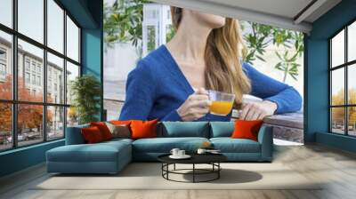 Woman with tea cup. Tea with sea buckthorn and honey on cafe bac Wall mural