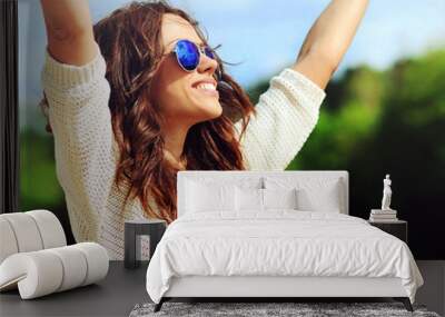 Attractive happy woman in sunglasses enjoying freedom outdoors w Wall mural