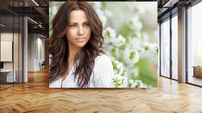 Beautiful woman in blooming garden in spring - close up portrait Wall mural