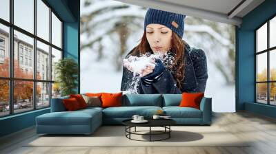 Winter woman blowing snow in a park Wall mural