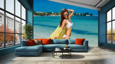 Young pretty woman in summer near the sea and blue sky in yellow Wall mural