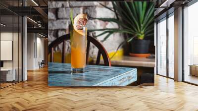 Orange tropical cocktail in hoghball glass on the blue table Wall mural