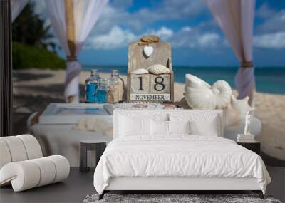 Close up view of table for the beach wedding ceremony with decoration of shells, jars with color sand, wooden calendar inside bamboo gazebo, Punta Cana, Dominican Republic Wall mural