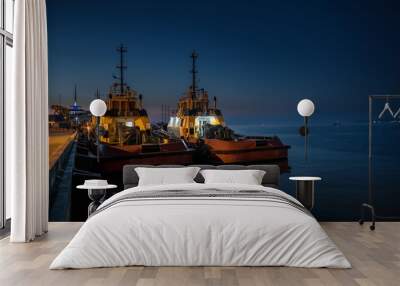 Dark view of two fishing boats mooring on pier in Batumi harbour. Night is coming and the sea is calm. Wall mural