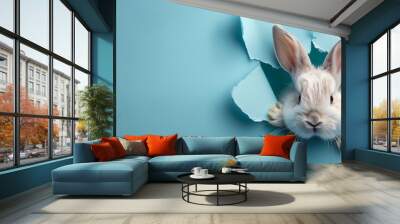 Easter banner with a white rabbit head breaking through a hole in a blue paper background Wall mural