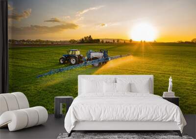 Farmer working in the field on a tractor until sunset. Wall mural