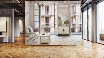 Front view to the vintage style living room with sofa, tile floor, retro lamps and balconies. Refurbished apartment in Barcelona old city Wall mural