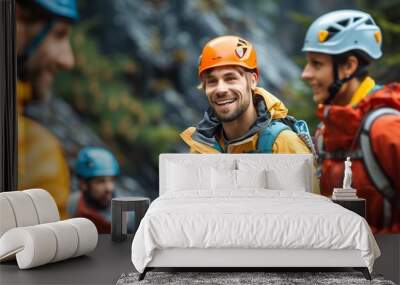 A group of climbers in colorful gear assist each other on a mountain trail Wall mural