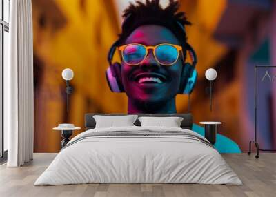 A young man smiles while listening to music through headphones, wearing sunglasses Wall mural