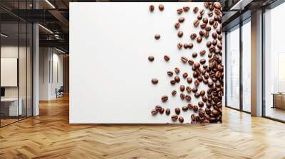 Brown coffee beans are spread across a plain white background Wall mural