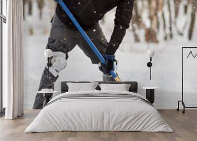 Alone hockey player going to slash puck at outdoor skating rink Wall mural