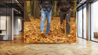 Detail of two friend in black jackets walk in autumn woods, front view Wall mural