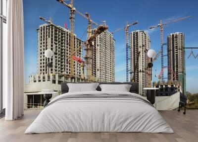 four tall buildings under construction with cranes against sky Wall mural