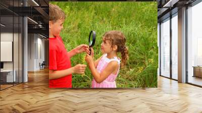 little brother and sister play with big black loop in nature Wall mural