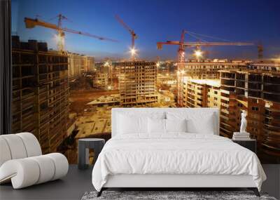 lots of tower cranes build large residential buildings at night. Wall mural