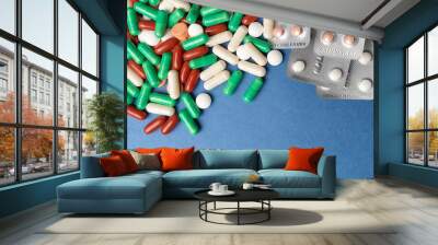 many multi-colored medical pills on blue background close-up Wall mural