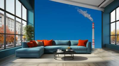 Smoke from a tall chimney in the clear sky, blue background and space for text, ecological theme Wall mural