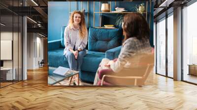 Happy red-haired woman talking to a female psychologist. Discusses her problems, mental trauma. Consultation in the office on the sofa. Positive mood. Wall mural