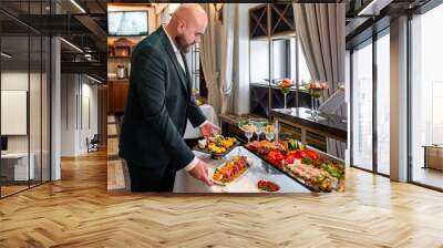 A person in a dark suit serves themselves at a buffet with various dishes, highlighting the concept of dining or catering service. The setting suggests a formal event or professional gathering. Wall mural