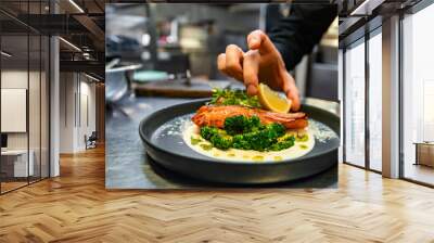 chef hand preparing a gourmet salmon steak with broccoli on restaurant kitchen Wall mural