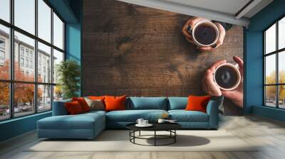 Cups of black tea in the hands of men and women. on a wooden background. with copy space. top view Wall mural