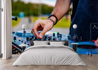 DJ Hands creating and regulating music on dj console mixer in concert outdoor Wall mural