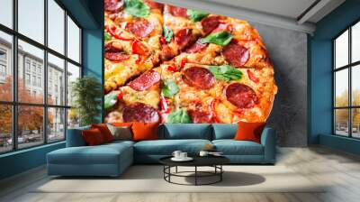 Pepperoni Pizza with Mozzarella cheese, salami, pepper, Spices and Fresh spinach. Italian pizza on Dark grey black slate background Wall mural