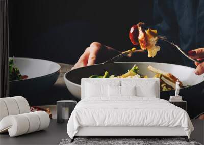 woman eating healthy salad from bowl sitting in cafe Wall mural