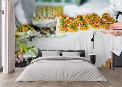 woman hands of a waiter prepare food for a buffet table in a restaurant Wall mural