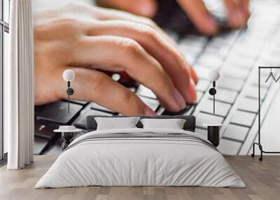 Woman working at home office hand on keyboard close up on wooden table background Wall mural