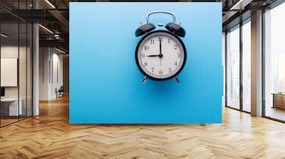 Black retro alarm clock showing nine o'clock, closeup top view clipping path, isolated on blue background. Time, deadline and morning routines concept Wall mural