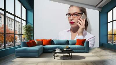 Attractive caucasian woman in stylish eyeglasses holding smartphone Wall mural