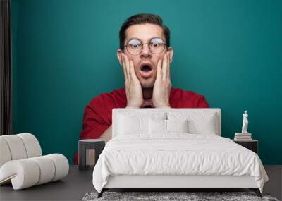 Close-up portrait of shocked young man in glasses Wall mural