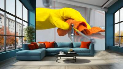 Closeup of woman's hand in yellow glove cleaning bath shelf Wall mural