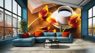 A Cup of coffee, beautiful spring tulips and a book on a natural wooden table Wall mural